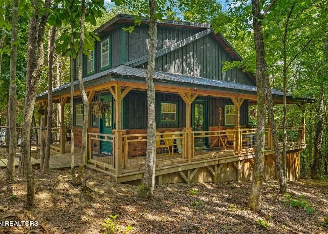 The off-grid cabin with its wraparound porch, seen from the yard