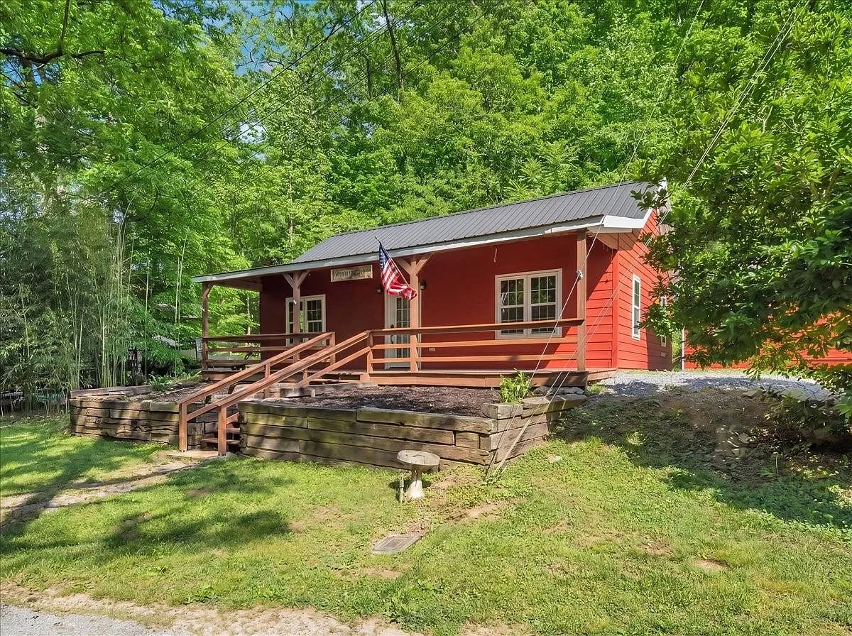 A red cabin with a huge covered front porch on 15.66 wooded acres near Smithville, Tennessee