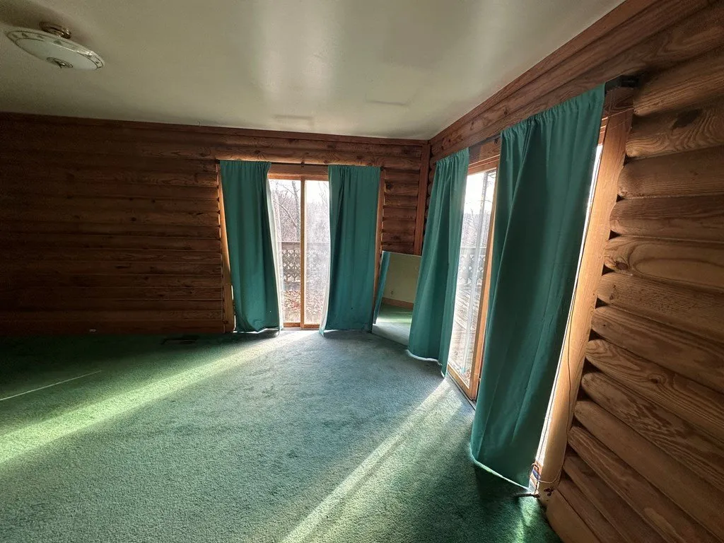 A bedroom with green curtains over the sliding door