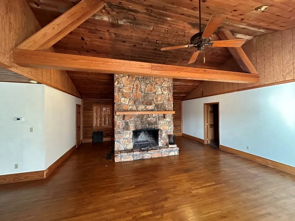 The stone fireplace under the cathedral ceiling and beams
