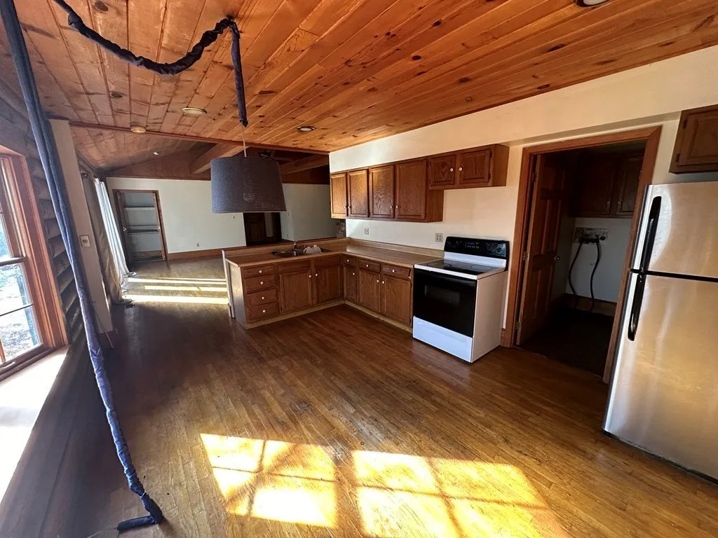 The kitchen with wood cabinets, a white range and a stainless refrigerator