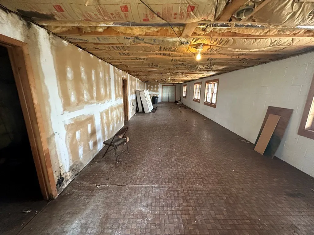 The unfinished basement with exposed joists and insulation