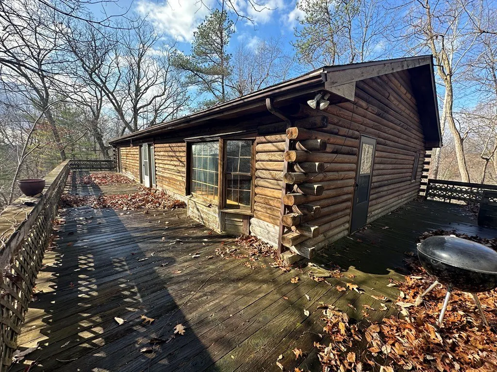 The deck wrapping the corner of the house, leaves on the boards