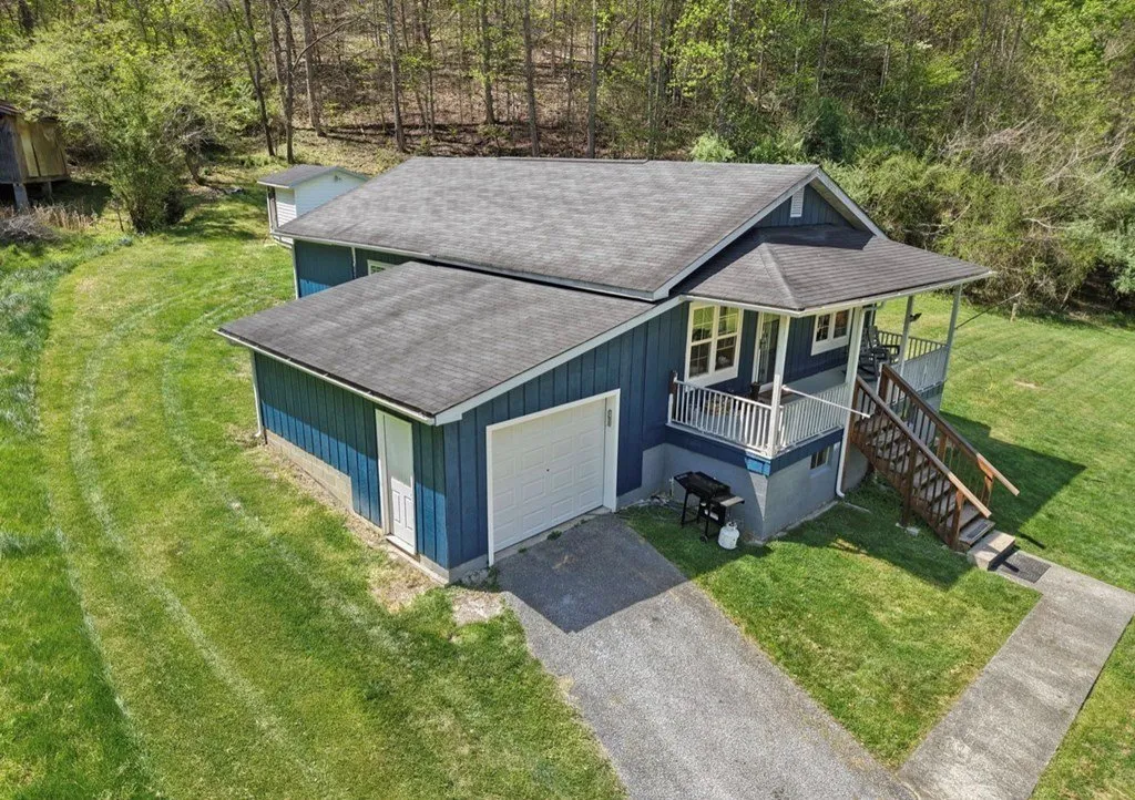 Aerial of the house and its outbuilding in the bottom, the hillside behind