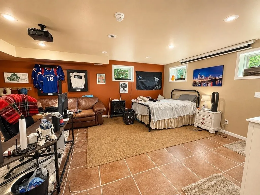 The lower-level family room with tile floors and orange walls