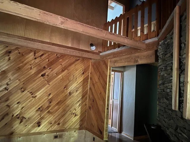 Inside the entry, log walls and the stairs to the upper floor