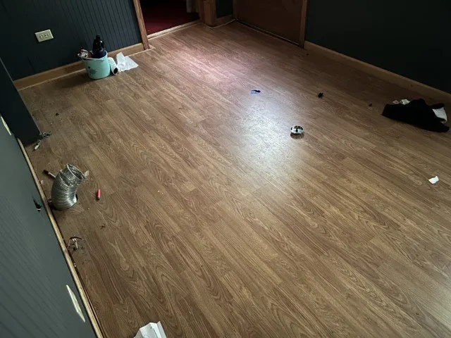 A room with laminate flooring and dark walls