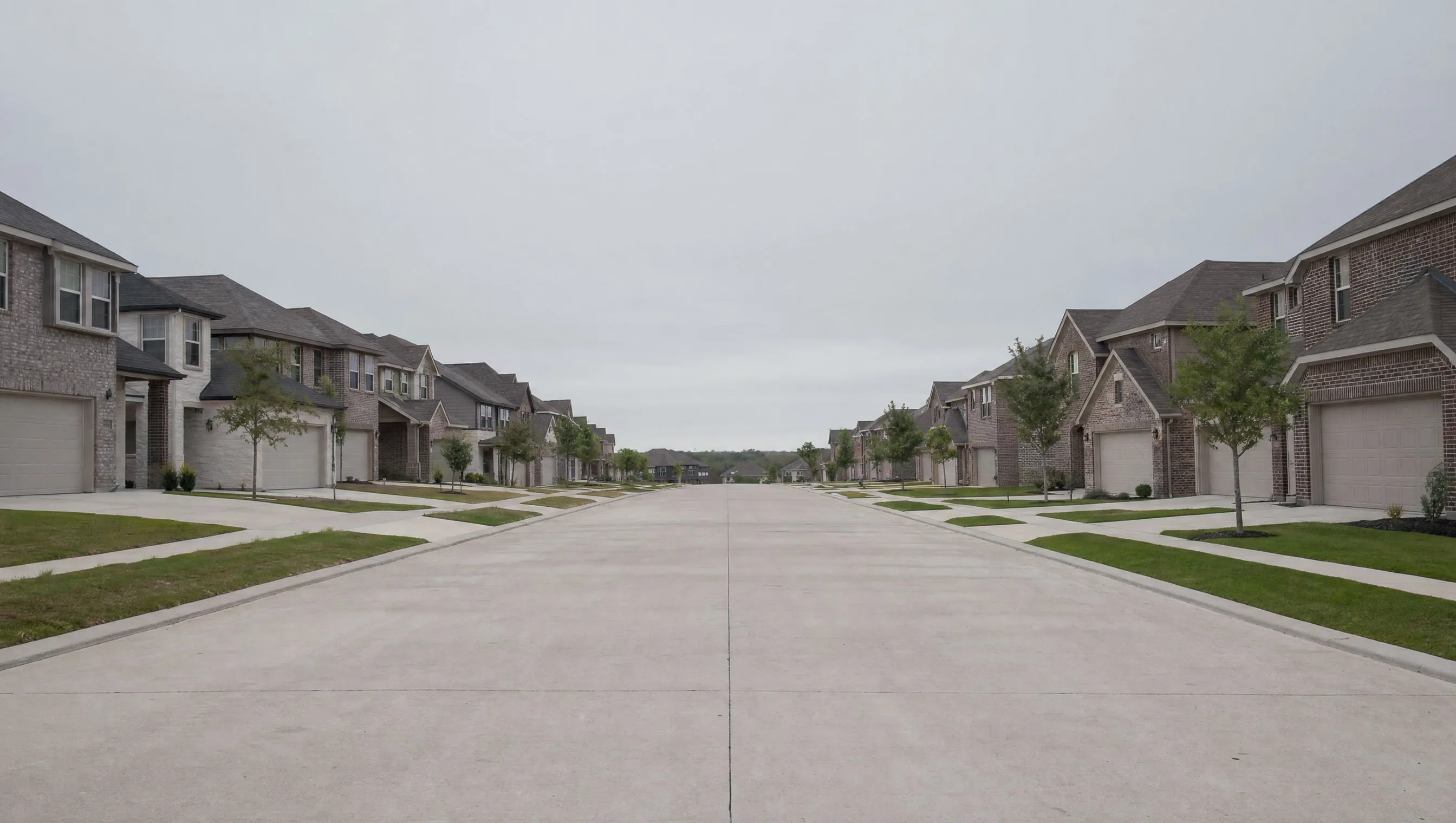 A wide street of similar houses in a newer subdivision