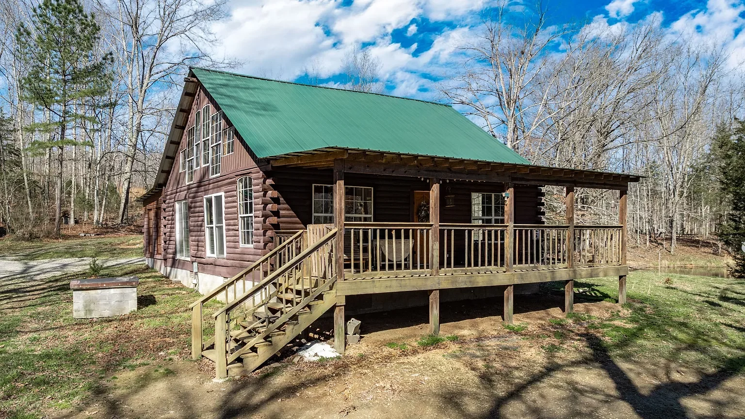 Secluded log cabin for sale in Lyles, TN on 6.5 acres with pond, garage, loft, and workshop. Explore this peaceful Tennessee retreat near Nashville today!